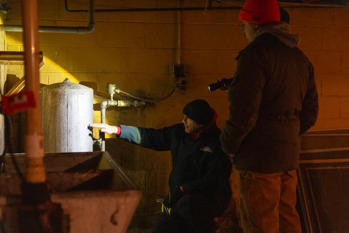 Academy student inspecting a water heater during an on-site inspection